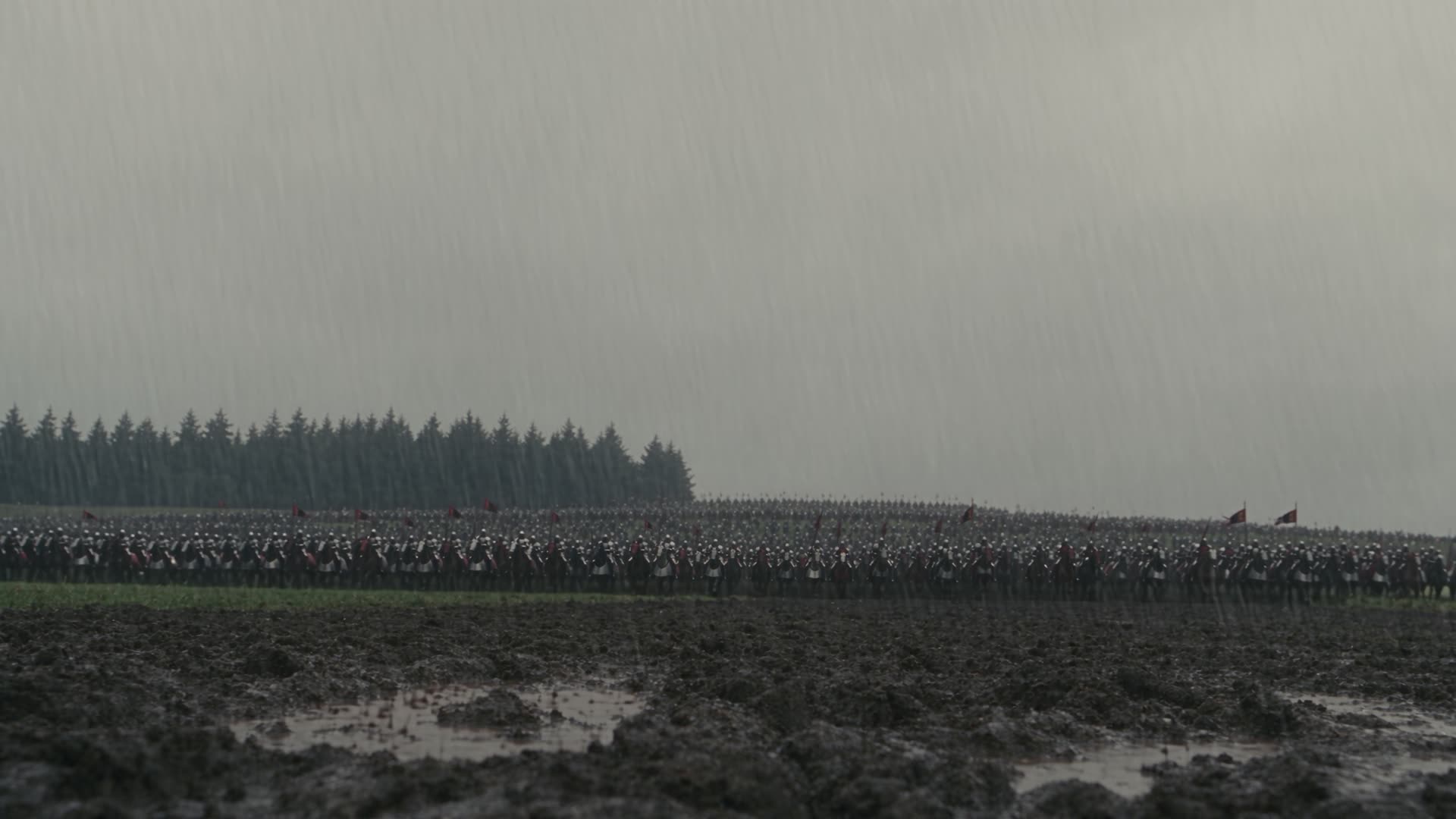 Army ranks on a rain-soaked battlefield under a grey sky